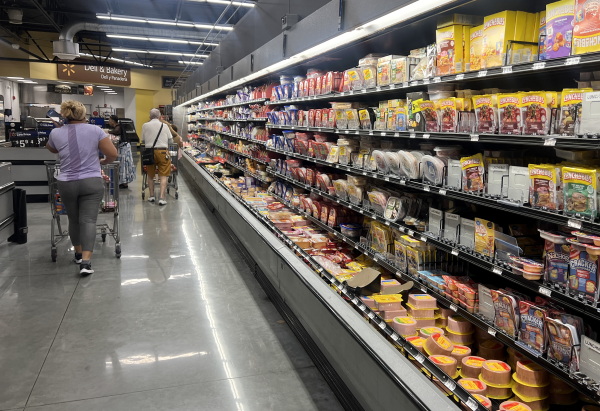 Customers shop in the deli meat aisle of a grocery store in Miami in October.