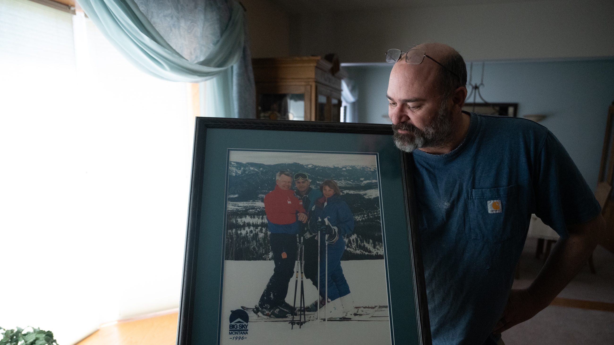 Casey Shively holds a photo of a family ski trip with his sister, Katie, and his father, Dan, in 1996. Dan Shively died in a memory care home after being violently attacked by another resident.