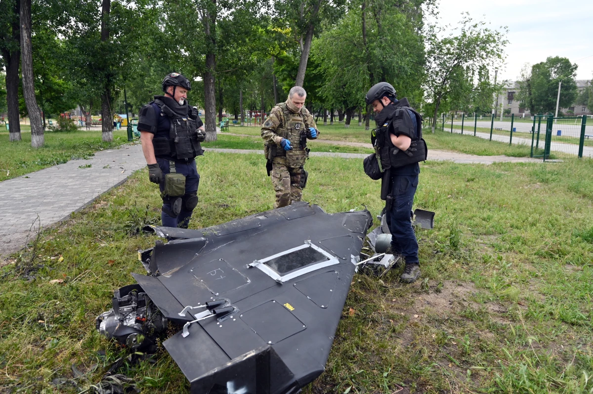 Ukrainian explosives experts and police officers examine parts of a Shahed 136 military drone following an air-attack in Kharkiv on June 4, 2025, amid the Russian invasion of Ukraine. (Photo by SERGEY BOBOK / AFP) (Photo by SERGEY BOBOK/AFP via Getty Images)