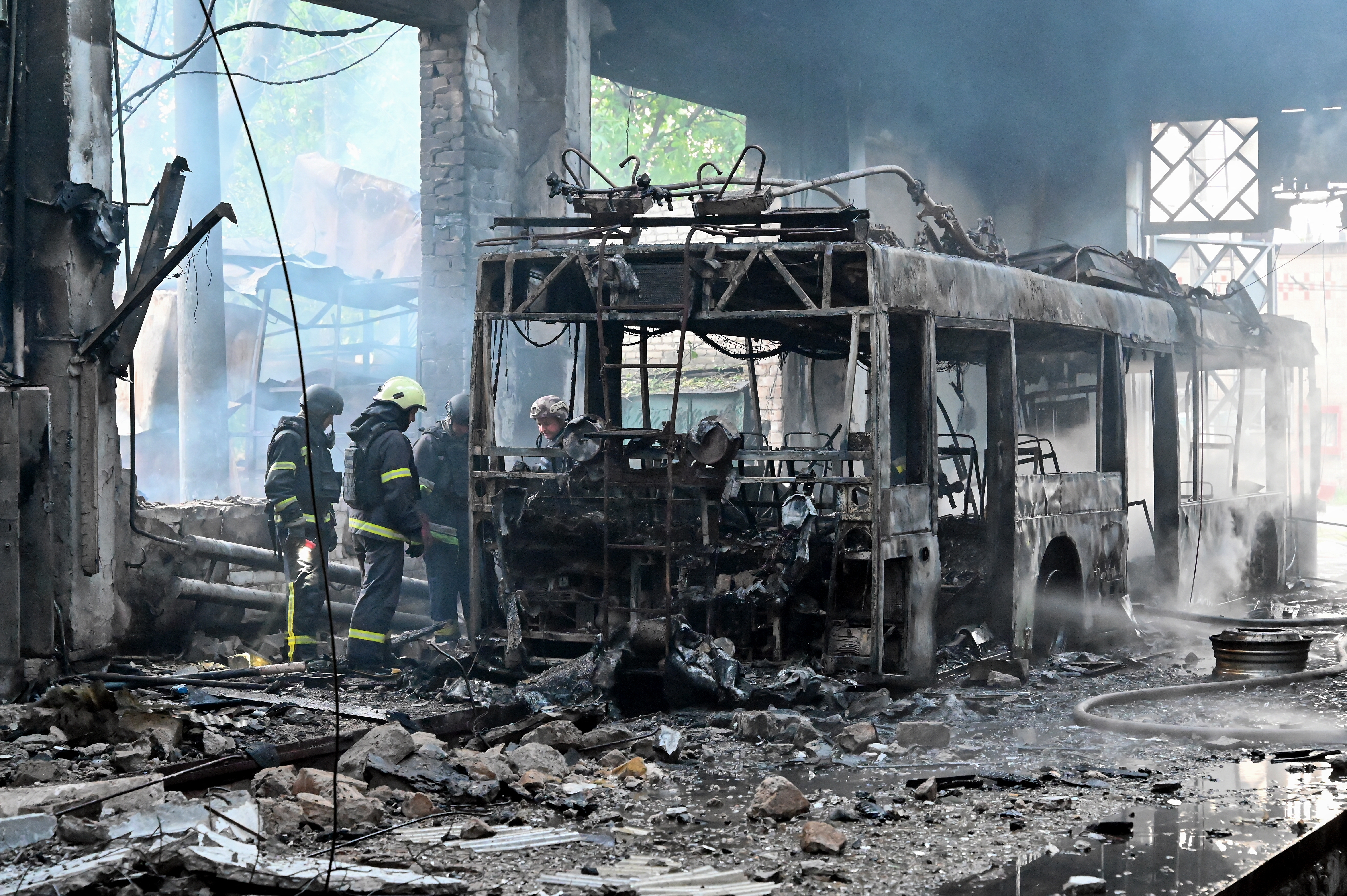 Ukrainian rescuers work to extinguish a fire in a trolleybus depot following a drone strike in Kharkiv on Friday, amid the Russian invasion of Ukraine.