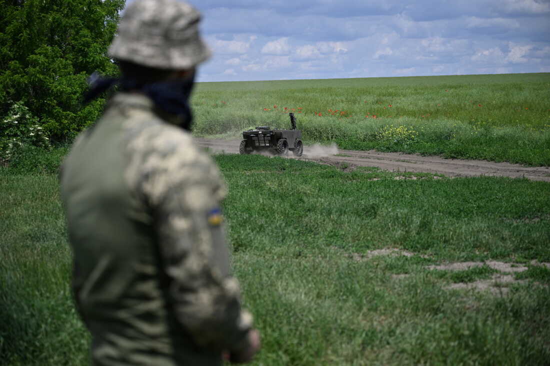 A Ukrainian serviceman controls a ground robot in a field test in the southeastern region of Zaporizhzhia in June. Ukraine is increasingly using ground drones for tasks that include delivering ammunition and medicine to frontline troops. Ukraine mounts machine guns on the robots to carry out attacks. The drones are also used to evacuate wounded soldiers in the dangerous Kill Zone.