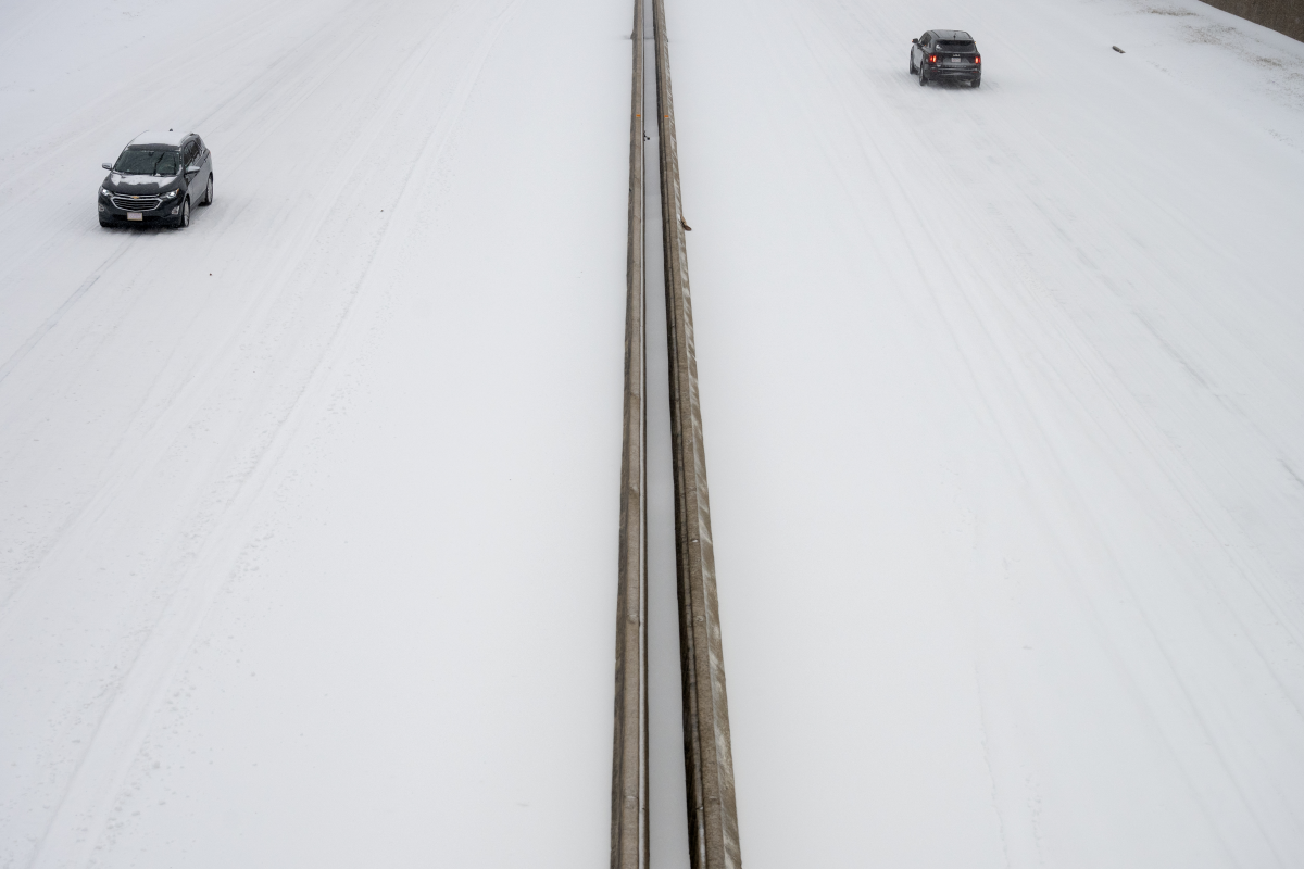 Cars drive in the snow on Interstate 630 in Little Rock, Arkansas.