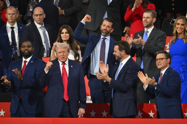 US former President and 2024 Republican presidential candidate Donald Trump (bottom, 2nd L) cheers alongside (from bottom L) US Representative of Florida Byron Donalds, US Senator from Ohio and 2024 Republican vice-president candidate J. D. Vance, and House Speaker Mike Johnson, (from top R) Co-chair of the Republican National Committee Lara Trump, son Eric Trump, son Donald Trump Jr., and US TV news personality Kimberly Guilfoyle as he arrives during the first day of the 2024 Republican National Convention at the Fiserv Forum in Milwaukee, Wisconsin, July 15, 2024.