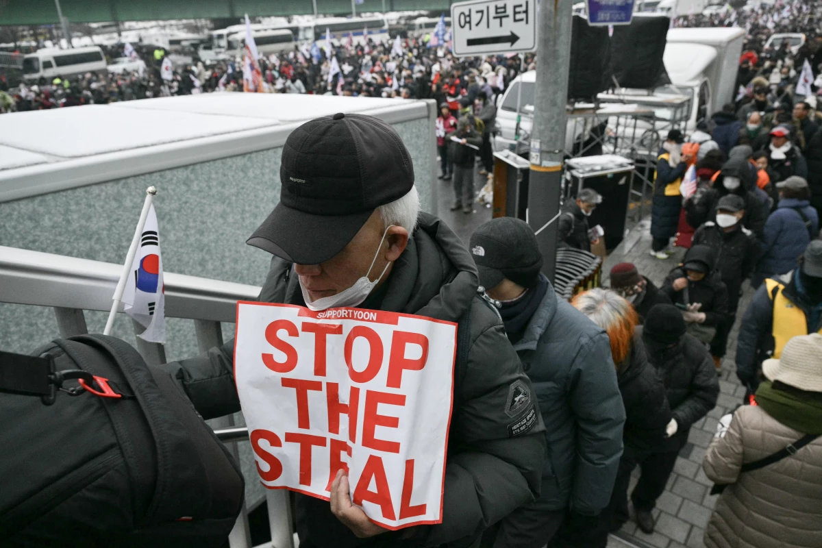 A supporter of impeached South Korean President Yoon Suk Yeol holds a placard reading 'Stop the Steal' as he takes part in a rally near Yoon's residence in Seoul on Sunday.