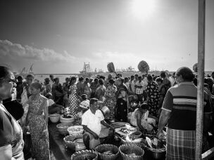 Vendors set up their baskets of the morning's catch on the docks, catering to customers that weave through the makeshift market.