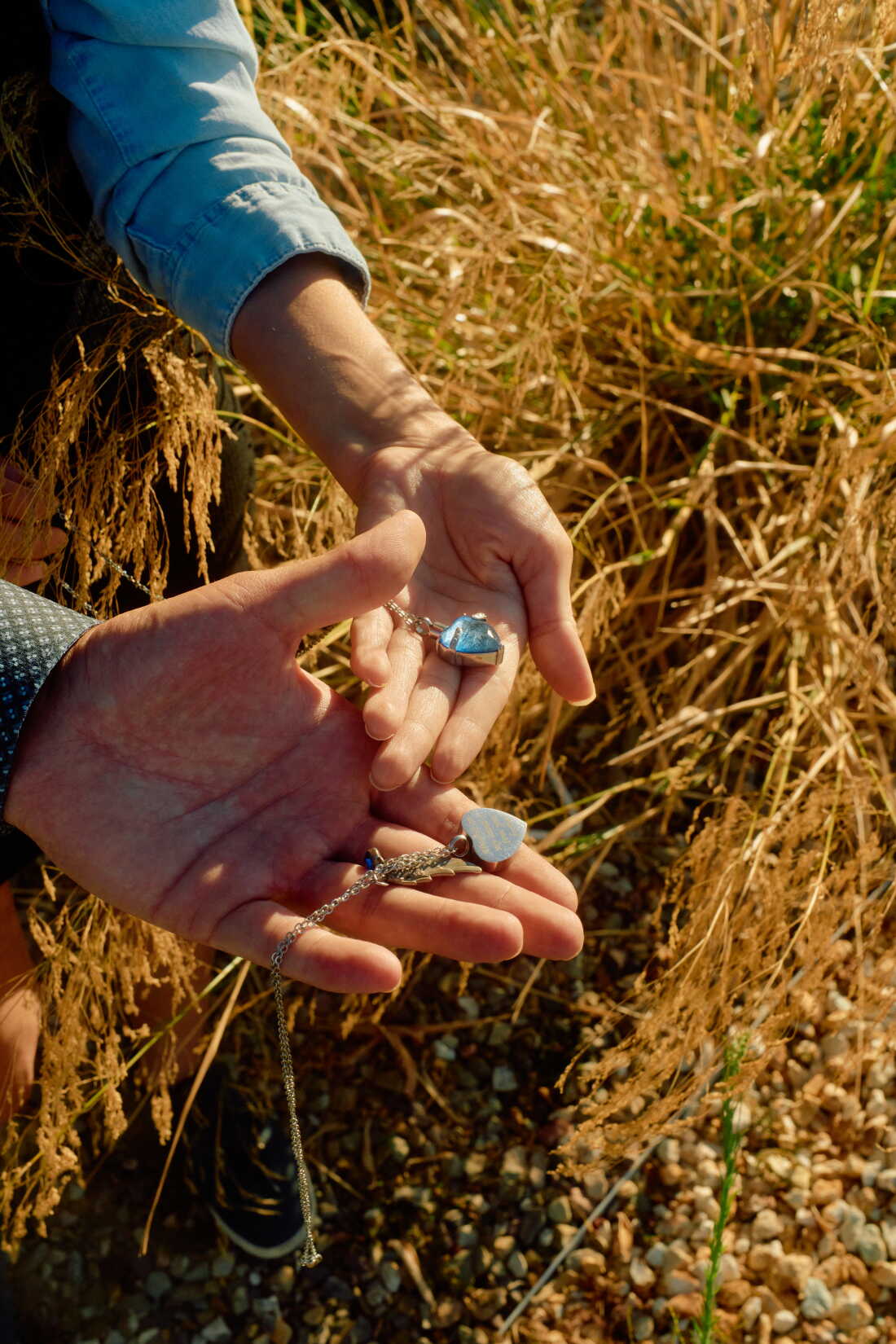 Habelitz and Morrow hold their necklaces containing Avery's ashes. The necklaces have a heart and silver wing charms.