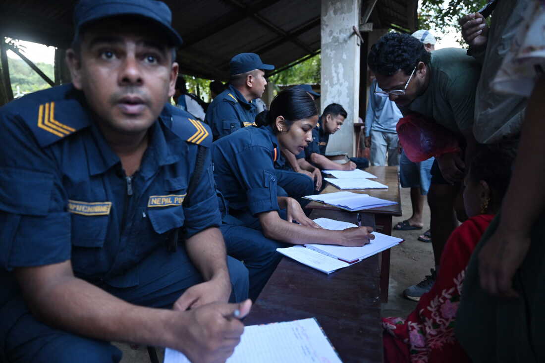 Nepal police collect details of missing people from relatives as they wait at Trishuli army camp, in Nepal's Nuwakot district.