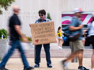 Mark Ehlers holds a sign outside the National Museum of American History in July 2026.