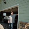 Lester Shreffler stands near his open garage door at his rental home in Farmersville, Texas.