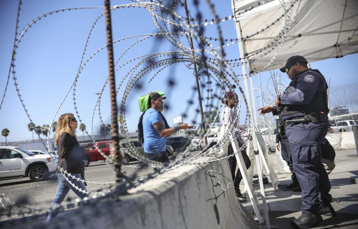 A U.S. Customs and Border Protection agent checks pedestrians' documentation at the San Ysidro Port of Entry in San Ysidro, California. A growing number of experts believe the flow of deadly street fentanyl from Mexico into the U.S. has been disrupted, contributing to a drop in fatal overdoses.