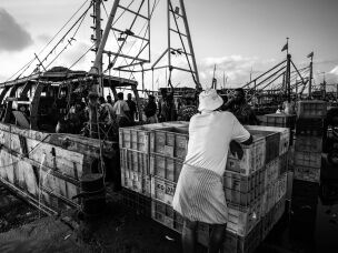 Workers gather beside a fishing boat at Kasimedu Fishing Harbour. built for fewer than 600 boats and now serving far more.