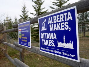 Political signs are posted on a property's fence in Wainwright, Alberta, Canada, Monday.