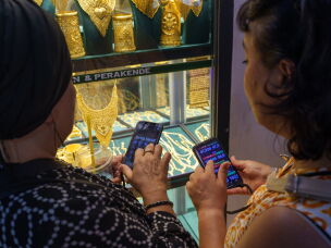 Women use their phones to calculate exchange rates before buying gold at the Grand Bazaar in Istanbul, Turkey, on Aug. 20, 2026.