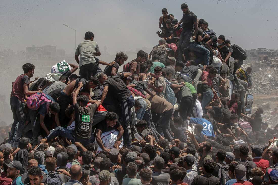 Title: Aid Emergency in Gaza Credit: © Saber Nuraldin, EPA Images Caption: Palestinians climb onto an aid truck as it enters the Gaza Strip via the Zikim Crossing in an attempt to get flour, during what the Israeli military called a “tactical suspension” in operations to allow humanitarian aid through. 27 July 2025. Story: In 2025, famine took hold amid what an independent UN Human Rights Commission inquiry has concluded is a genocide in Gaza. Israel disputes this. Israeli authorities imposed a complete aid blockade in March, a tactic described by humanitarian organizations as the weaponization of starvation. When international pressure led to a partial reopening of crossings in May, most deliveries went through the Gaza Humanitarian Foundation (GHF), established by the US and Israel to bypass the UN-led aid system. Its operation, which put military personnel in charge, was widely condemned by global human rights and legal organizations as unethical and in violation of international law. The UN reports that between late May and early October, at least 2,435 Palestinians were killed seeking food at or near GHF collection points. The GHF shut down when a fragile ceasefire went into effect in October. Despite some aid entering Gaza, more than 75% of the population still faced hunger and malnutrition in December. The photographer was born in Gaza and has documented life there since 1997.