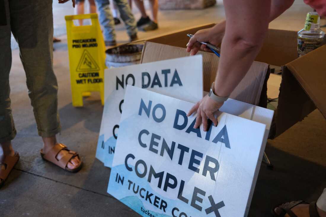 Volunteers hand out yard signs in June against a data center complex in West Virginia.