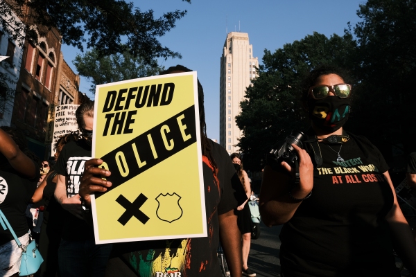 A protester carries a sign that reads "Defund The Police" during a July 3, 2020 march in Richmond, Va. Many Democrats have been wary of calls to "abolish ICE," and point to how calls to "defund the police" hurt the party with voters in 2020 and 2024.
