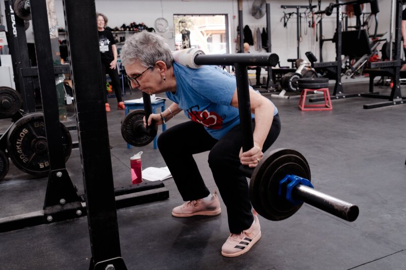 A young farmer smiles ‍while tending to crops in a‌ field.