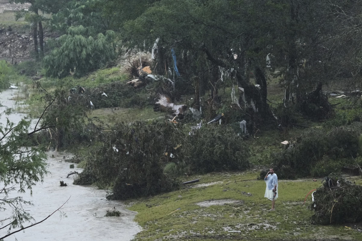 A man surveys damage left by a raging Guadalupe River in Kerrville, Texas.