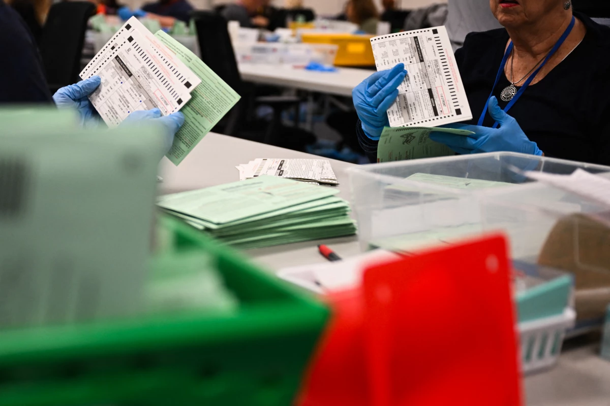 Election workers open and inspect mail-in ballot envelopes for Arizona's 2024 general election inside the Maricopa County Tabulation and Election Center in Phoenix.