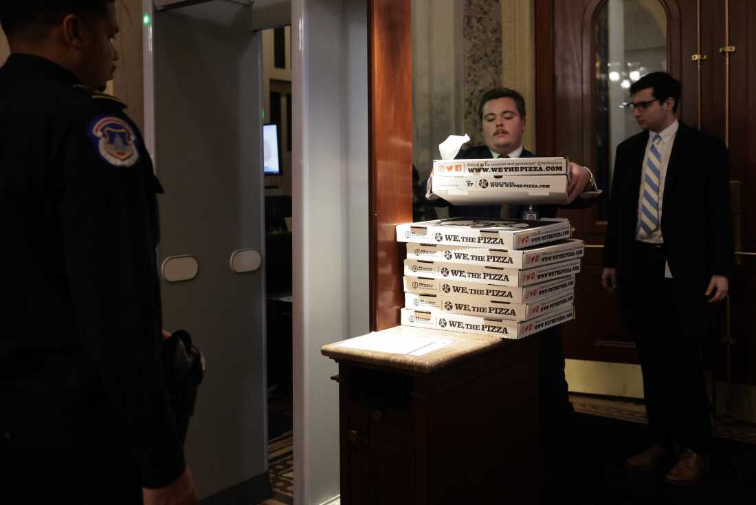 Workers bring boxes of pizza into the U.S. Capitol ahead of a Senate "vote-a-rama" on Feb. 20, 2025 in Washington, D.C.