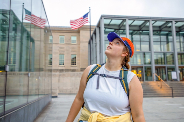 Lights Out DC volunteer Alex Raycroft searches a glass overhang for birds on Sept. 13, 2024. Every morning for nearly 10 weeks each spring and fall, volunteers search the streets of Washington, D.C. for dead or injured birds that didn’t make it out of the city as they were migrating through the area overnight.