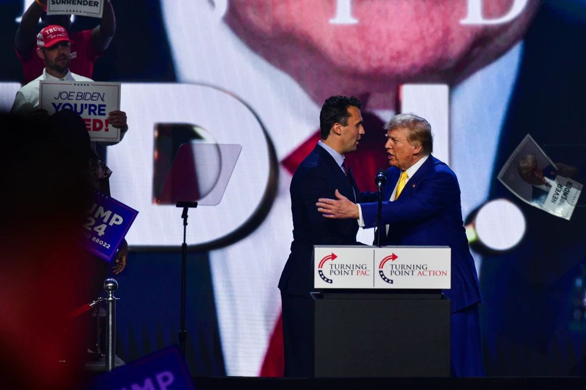Former President Donald Trump embraces Turning Point's Charlie Kirk at Dream City Church in Phoenix on Thursday.