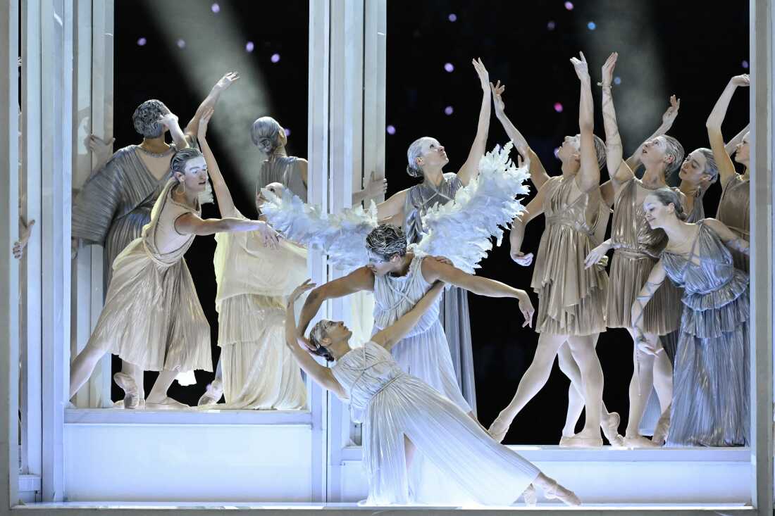 Italian ballet dancers Antonella Albano and Claudio Coviello dressed as angels in all white perform with at least a dozen dancer behind them during the opening ceremony.