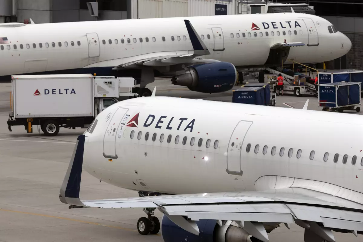 U.S. airline regulators have opened an investigation into Delta Air Lines, which was still struggling to restore operations on Tuesday, more than four full days after a faulty software update caused technological havoc worldwide and disrupted global air travel. Here, a Delta Air Lines plane leaves the gate on July 12, 2021, at Logan International Airport in Boston.