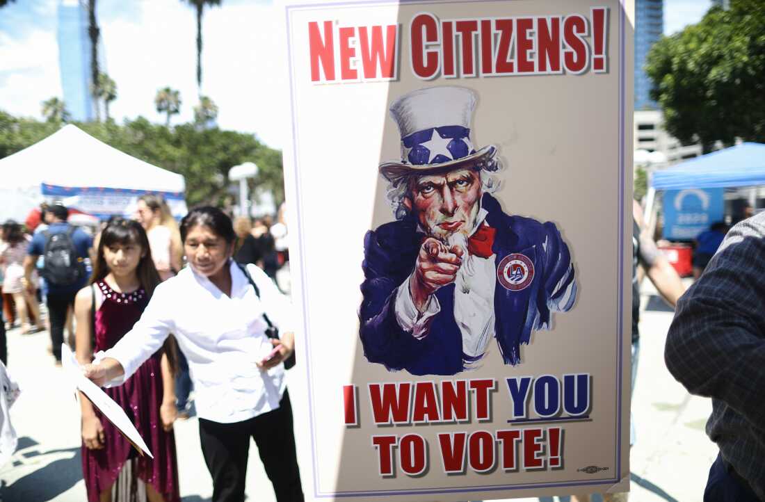 A sign is posted at a voter registration booth outside a naturalization ceremony at the Los Angeles Convention Center on July 23, 2019.