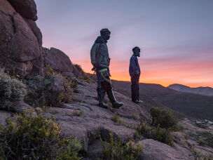 Shepherds Lapeli Maapesa and Kabelo Mohai take a break while trekking down from their cattle posts in the mountains to attend class at the Good Shepherd night school in Semonkong, Lesotho. Some shepherds walk as long as two hours to attend their night classes.