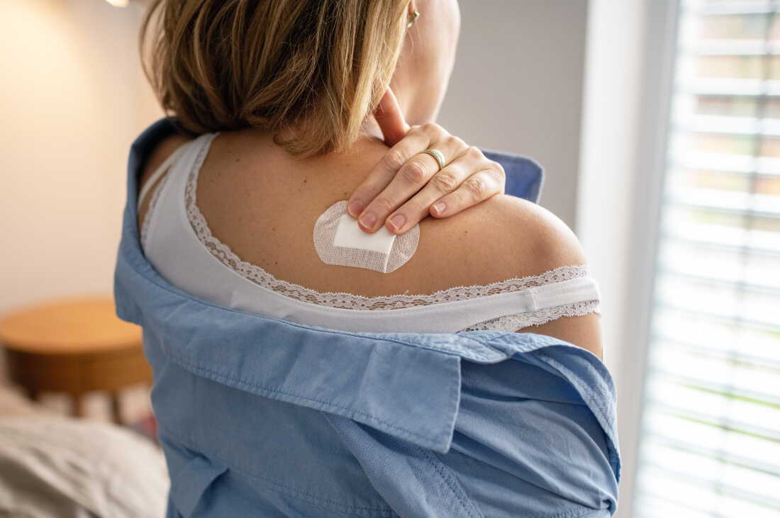 Person applying estrogen patch.