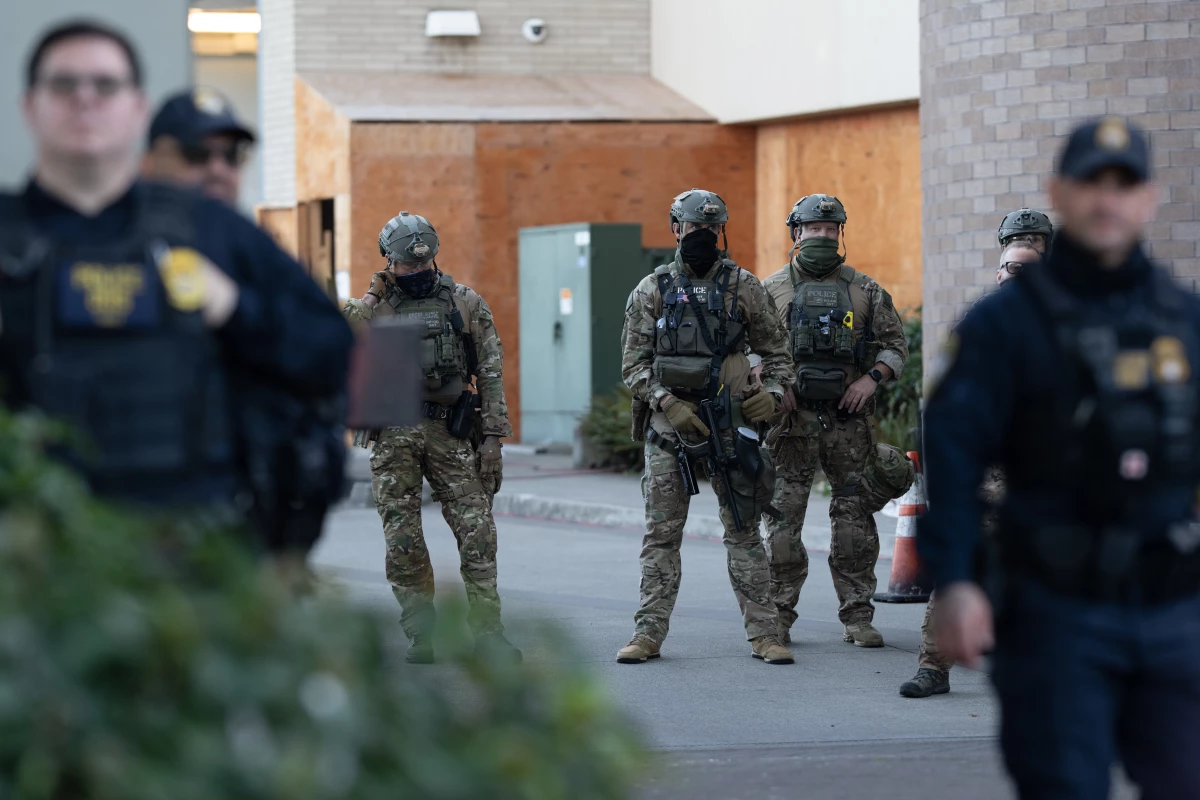 Law enforcement officers look out from a United States Immigration and Customs Enforcement (ICE) facility Oct. 21, 2025, in Portland, Ore.