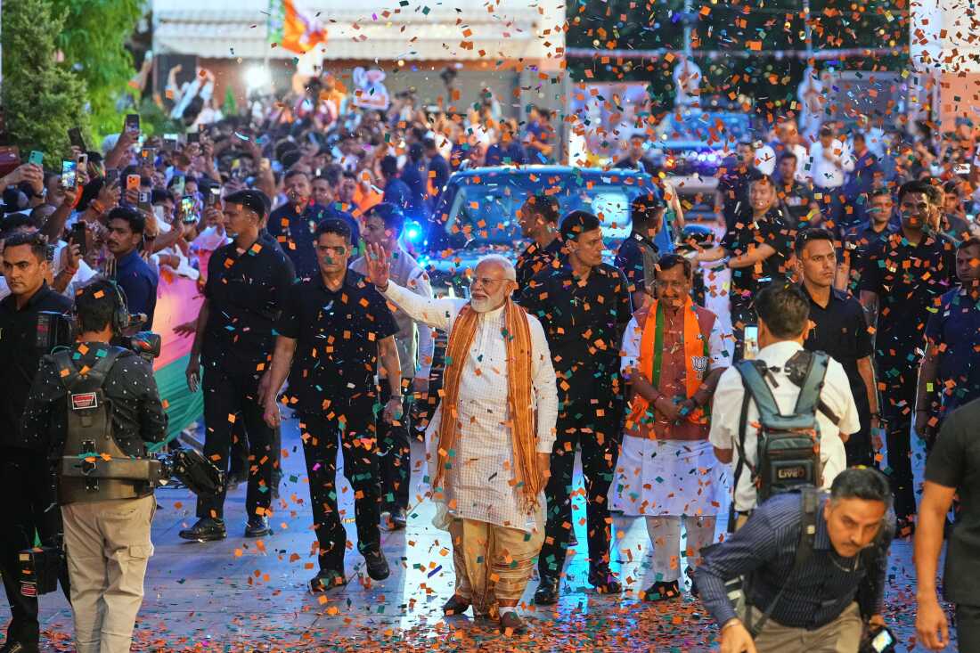 Confetti is sprayed as Indian Prime Minister Narendra Modi, center, waves to supporters upon his arrival at the Bharatiya Janata Party (BJP) headquarters to celebrate victory in the recently held state assembly elections in New Delhi, India, Monday, May 4, 2026.