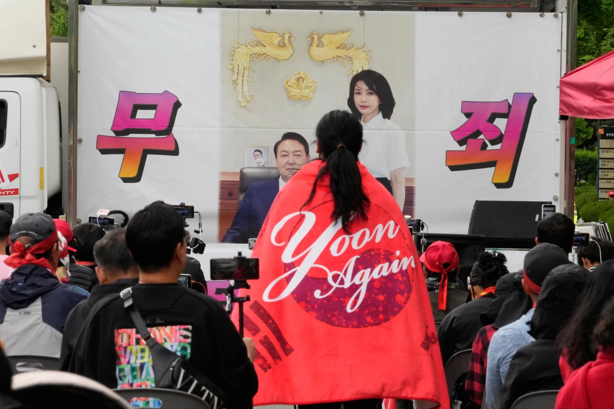 An image of former South Korean President Yoon Suk Yeol and his wife Kim Keon Hee is seen during a rally by supporters outside of the Seoul High Court in Seoul, South Korea, Tuesday, April 28, 2026. The letters read 'Not Guilty.'