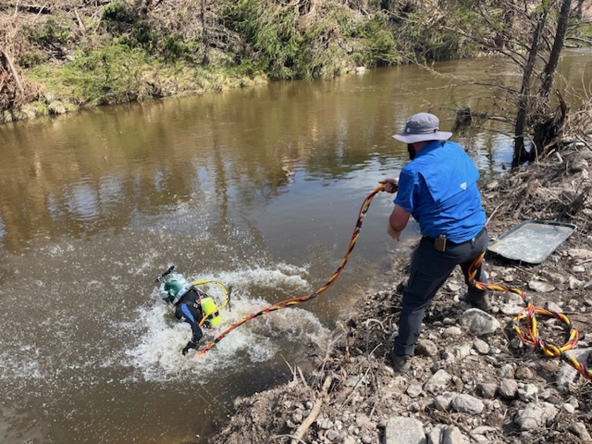 Volunteer divers with the Christian nonprofit 'Heroes 4 Humanity' search the Guadalupe River near the town of Hunt, Texas.
