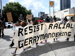 Protesters hold a banner reading