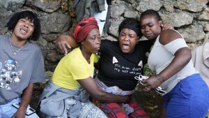 Women cry at the site where their relatives were killed in a gang attack in the Kenscoff neighborhood of Port-au-Prince, Haiti, Monday, Aug. 24, 2026.