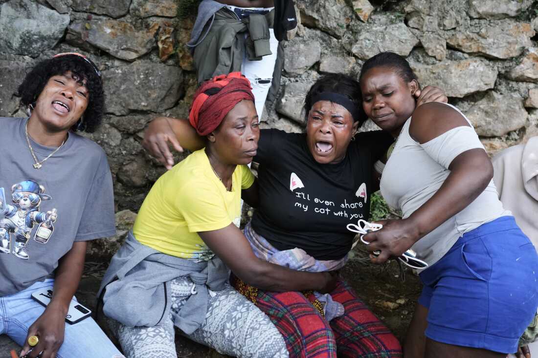 Women cry at the site where their relatives were killed in a gang attack in the Kenscoff neighborhood of Port-au-Prince, Haiti, Monday, Aug. 24, 2026.