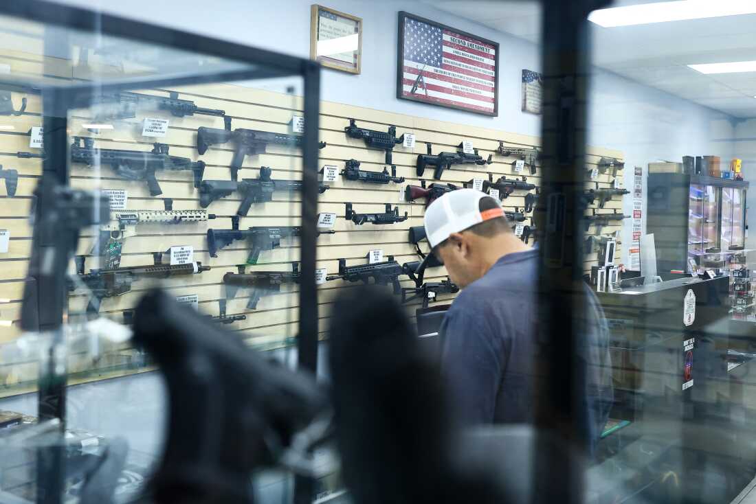 A customer browses as firearms are displayed for sale in a gun store in Rio Rico, Santa Cruz County, Arizona on Sept.17, 2025.