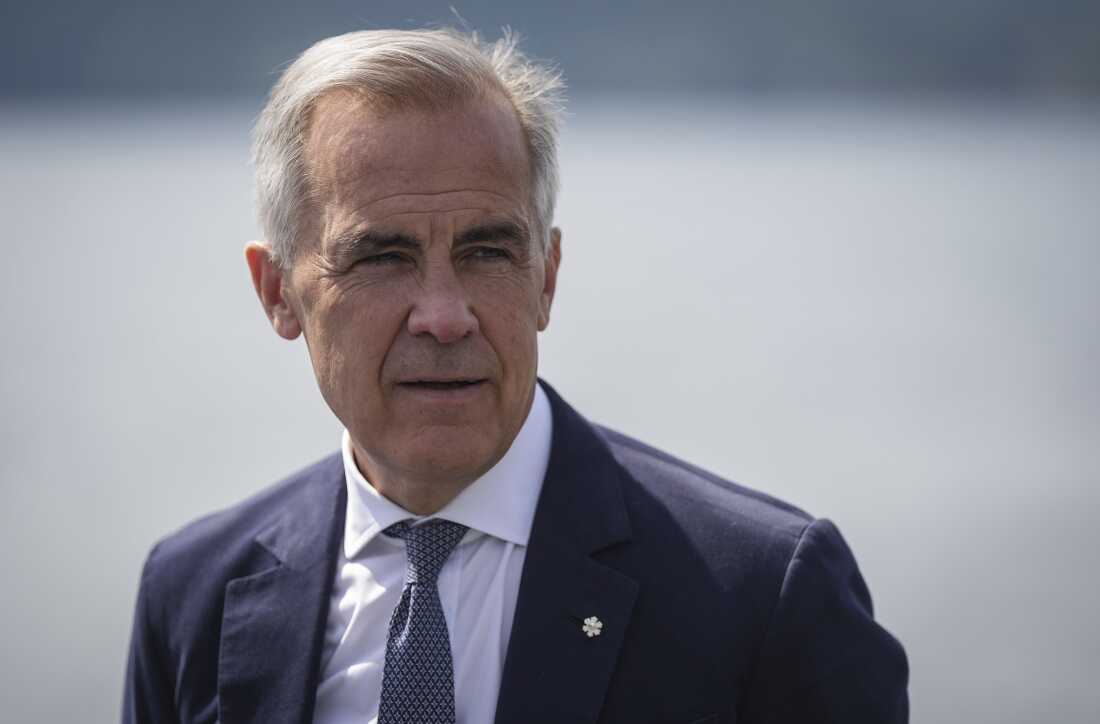 Canada's Prime Minister Mark Carney listens while touring the Royal Canadian Navy torpedo recovery vessel Sikanni at the Canadian Forces Maritime Experimental and Test Ranges, in Nanoose Bay, British Columbia, Aug. 4.