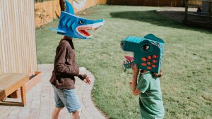 A brother and sister enjoy an imaginative game in a domestic garden on a sunny day. Siblings can have a powerful effect on one another.