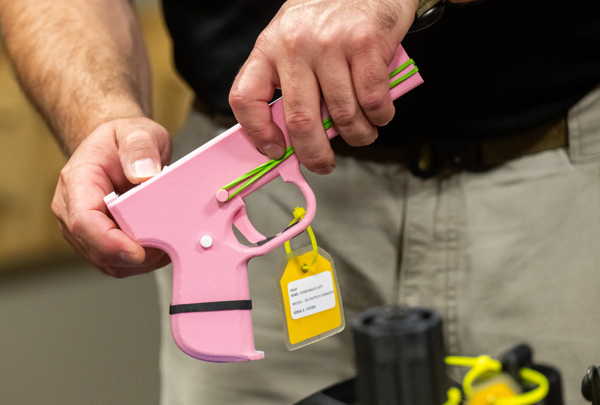 An ATF official holds a 3D-printed gun in the National Firearm Reference Vault, which holds thousands of guns, at the Bureau of Alcohol, Tobacco, Firearms and Explosives (ATF) National Services Center in Martinsburg, West Virginia, Sept. 4, 2024.