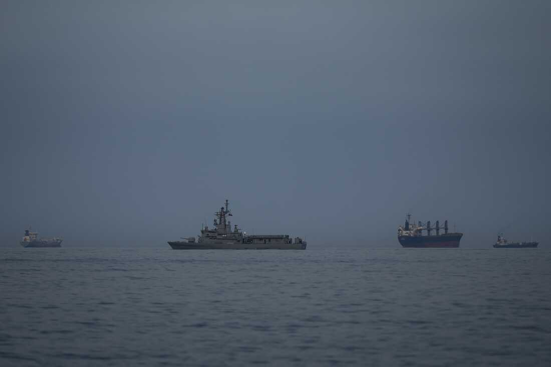 A United Arab Emirates navy vessel patrols next to cargo ships and oil tankers in the Strait of Hormuz, as seen from Khor Fakkan, United Arab Emirates, March 11.