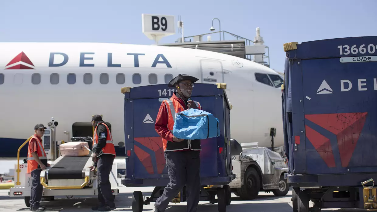 Delta Air Lines ramp agent Mike Davis prepares to load passenger luggage on his cart while working at Hartsfield-Jackson Atlanta International Airport, on May 13, 2026.