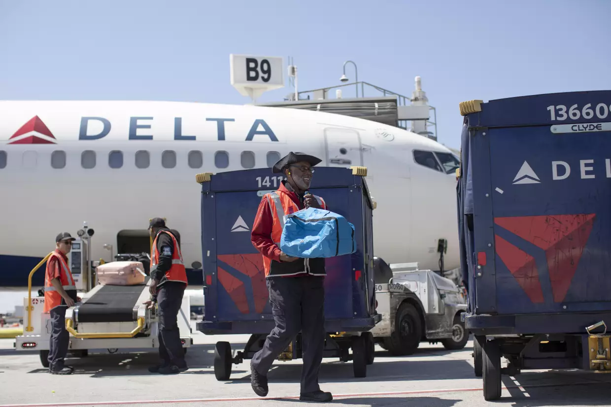 Delta Air Lines ramp agent Mike Davis prepares to load passenger luggage on his cart while working at Hartsfield-Jackson Atlanta International Airport, on May 13, 2026.