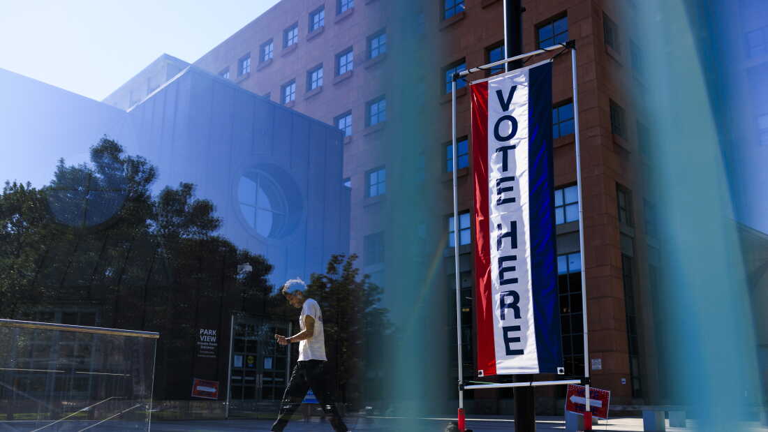 People walk by a polling place at Denver's Central Library on June 30, 2026.
