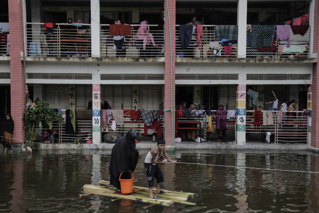 People use boat made out of banana branches to commute from temporary flood shelter camp to the main street to buy daily essential in Feni, Chittagong, Bangladesh, August 26.