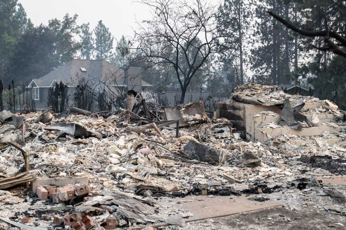 The rubble of a burned out home smolders in the Balboa neighborhood of Spokane, Wash., on Sunday. Fast-moving fires left a trail of destruction on Sunday, with officials reporting hundreds of structures reduced to cinders. Thousands of people were ordered to evacuate their homes Saturday and overnight into Sunday, as three separate fires broke out in and around the city in the east of Washington state.