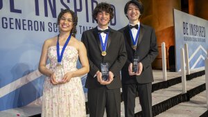 The top three winners of the Regeneron Science Talent Search: Matteo Paz (center) - First Place; Ava Grace Cummings (left) - Second Place; and Owen Jianwen Zhang (right) - Third Place, celebrating their achievements at the awards ceremony.