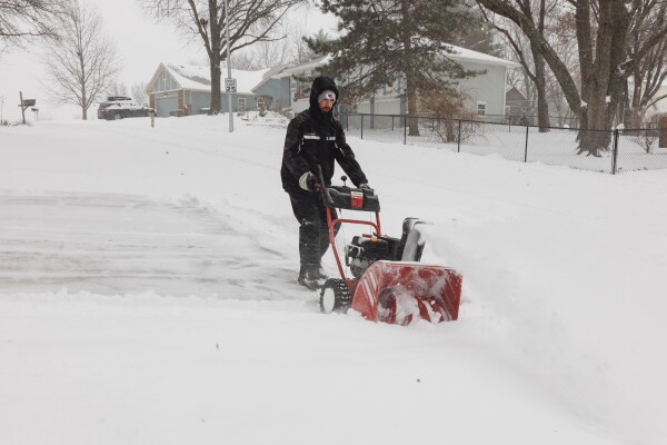 Darin Campbell uses a snow blower to remove snow from his driveway on Sunday in Shawnee, Kansas.